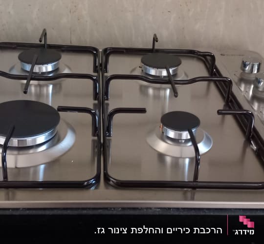 כיריים גז עם ארבעה מבערים וכפתורי שליטה
